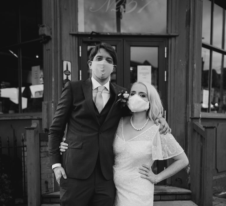 Bride and groom pose in face masks