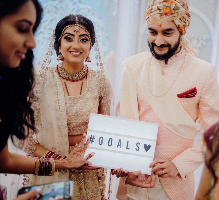 Bride & groom hold up #Goals wedding sign 