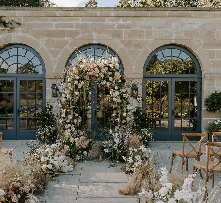 The Fig House outdoor wedding ceremony at Middleton lodge with neutral fresh and dried flower arrangements decorating the aisle and altar