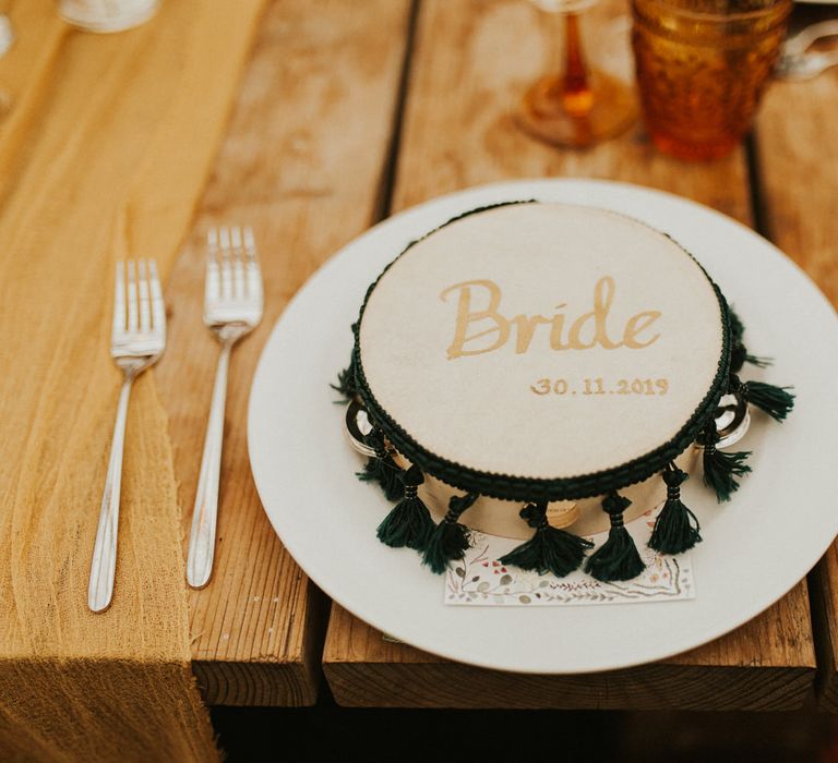 Moroccan themed tambourine wedding favours and name place settings embroidered with the wedding date 