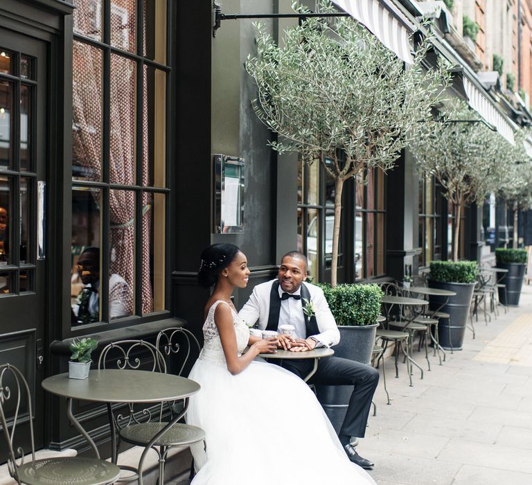 Bride & groom sit at outdoor cafe in London