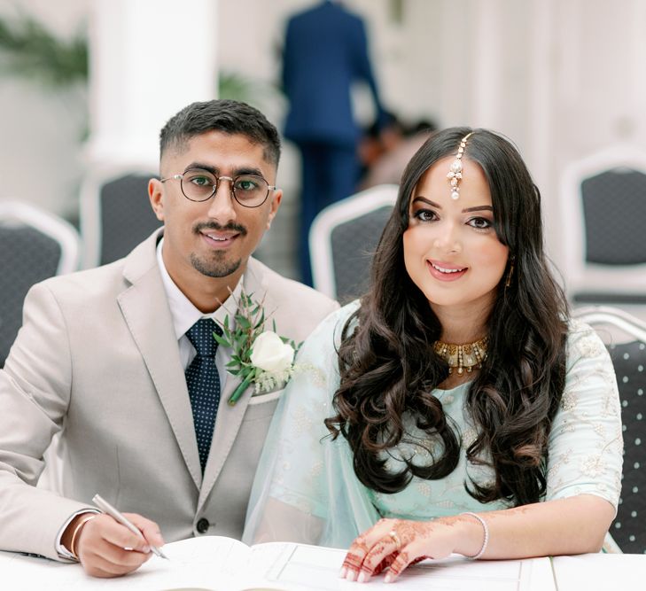 Islam bride and Sikh groom signing the register at intimate wedding ceremony 