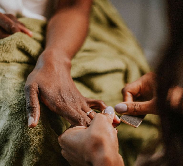 Bride gets her nails done over green blanket before Bridge Community Church wedding