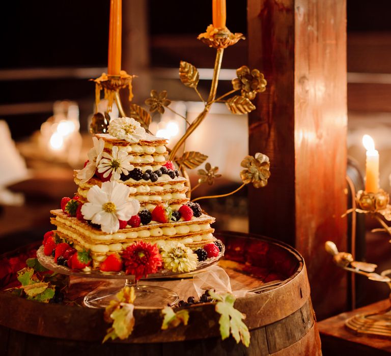 Italian dessert wedding cake made of pastry and meringue, decorated with flowers and placed on a barrel