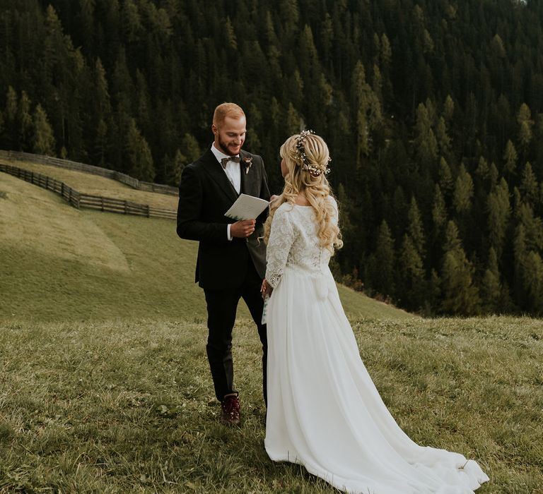 Groom reading is vows at Dolomites Autumn elopement 