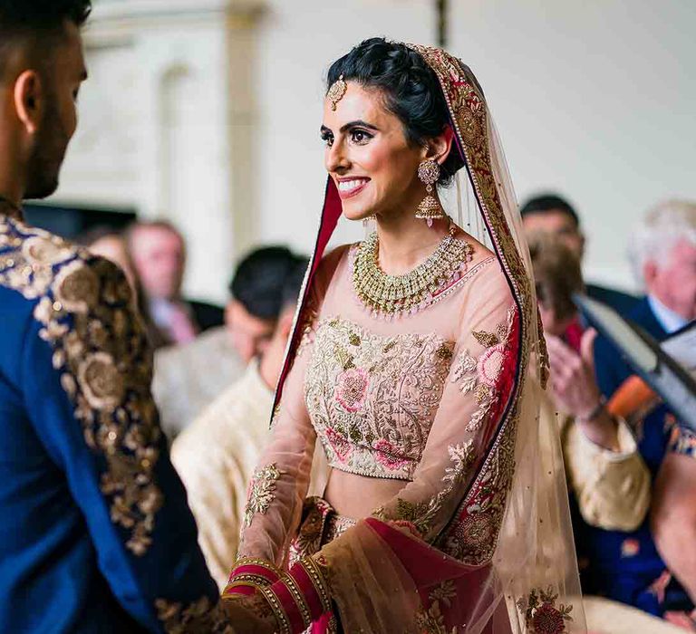 Bride holds grooms hands at Hindu fusion wedding