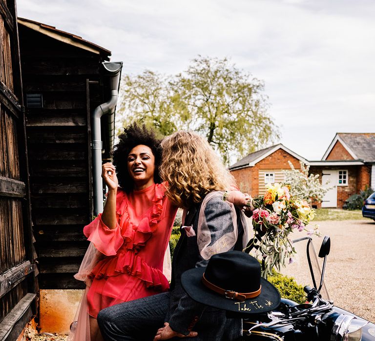 Stylish bride and groom sitting on a motorcycle 