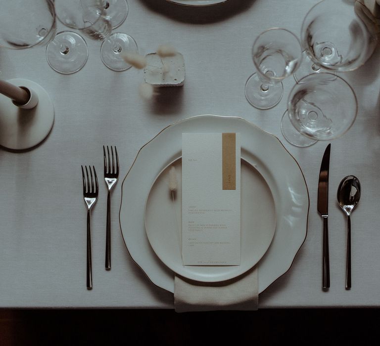 Arial view of minimalist decor for a simple elegant wedding table including dried grasses, bunny tails and white ceramics.