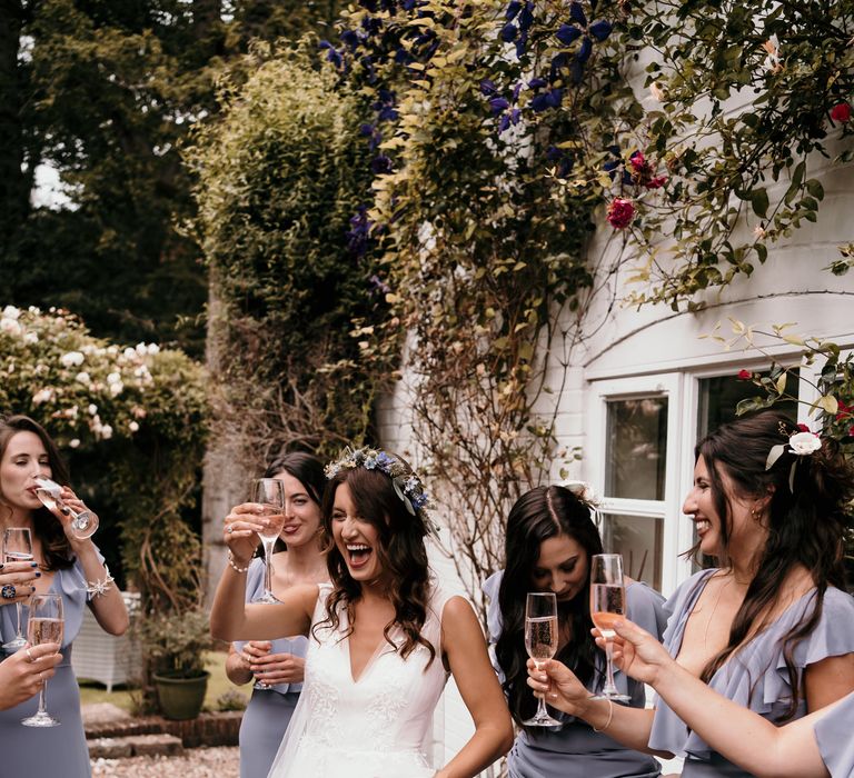 Bride celebrates with bridesmaids outdoors as they cheers champagne 