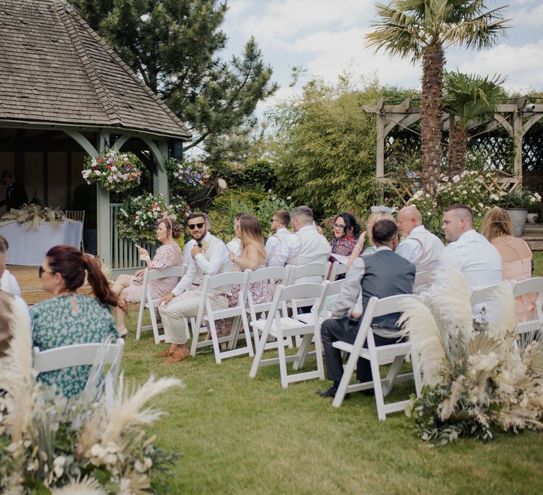 Intimate outdoor wedding ceremony at Cooling Castle Barn with pampas grass floral arrangements 