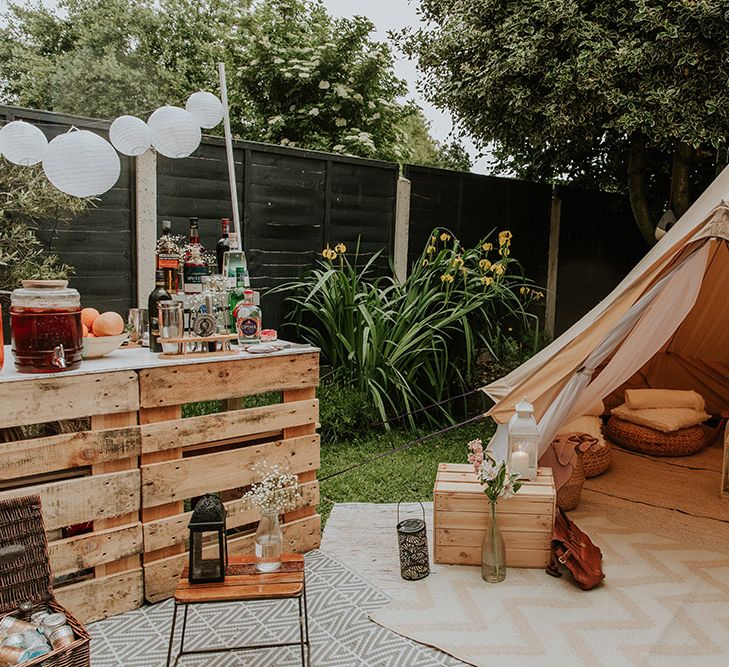 Back garden wedding reception with tipi chill out area and DIY wooden palette bar 