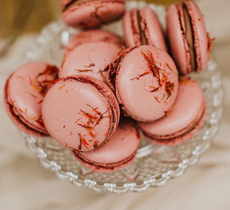 Pink macaroons on a glass cake stand 