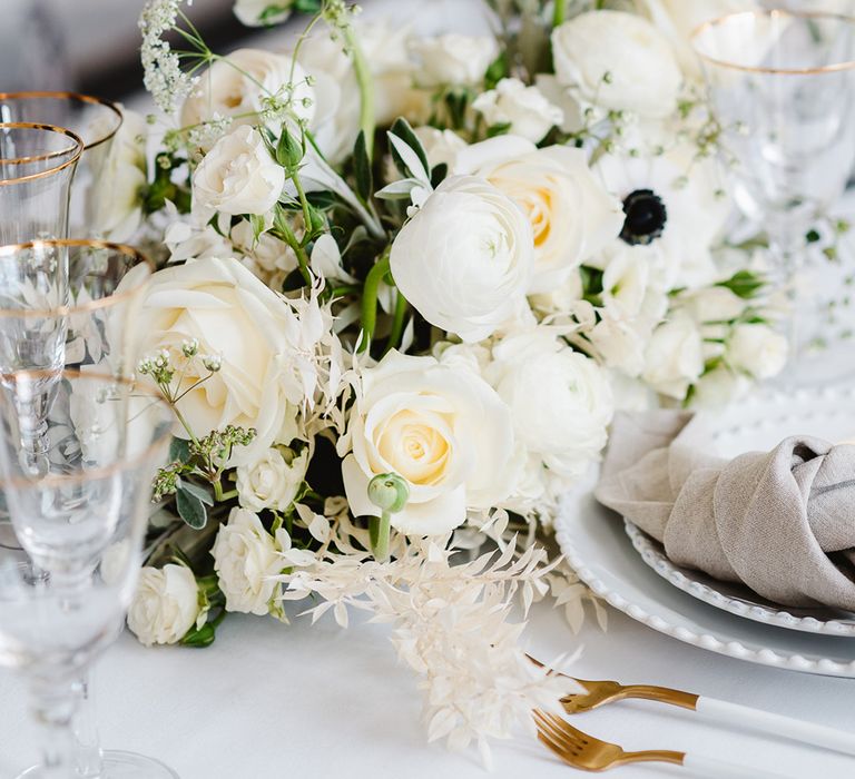 Close up of a black and white wedding bouquet including ranunculus, roses and anemones.