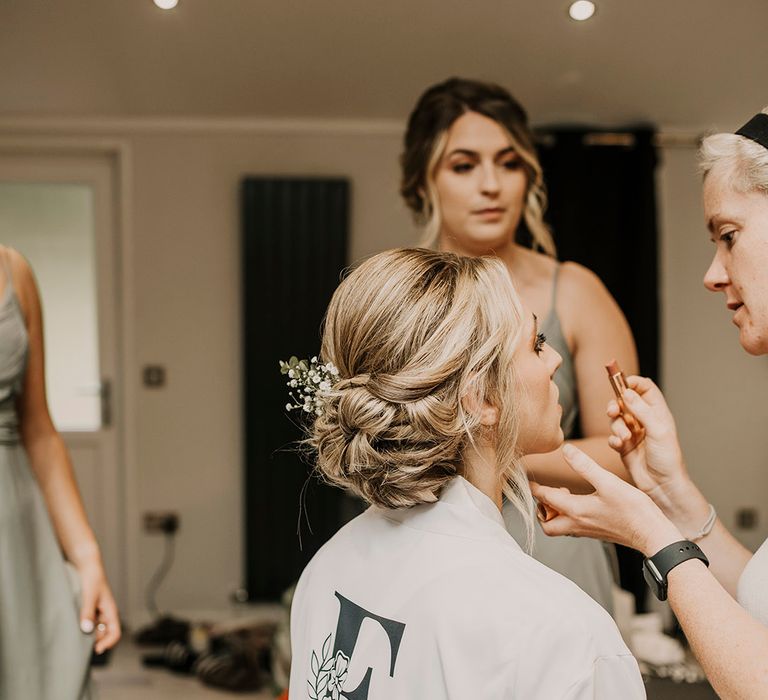 Pinned bridal updo with floral hairpiece