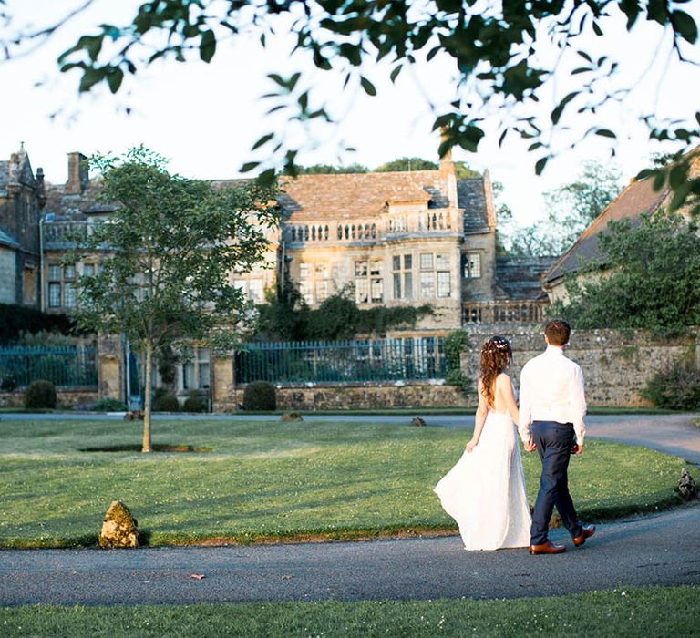 Bride & groom stand within the lush grounds of Mapperton on their wedding day