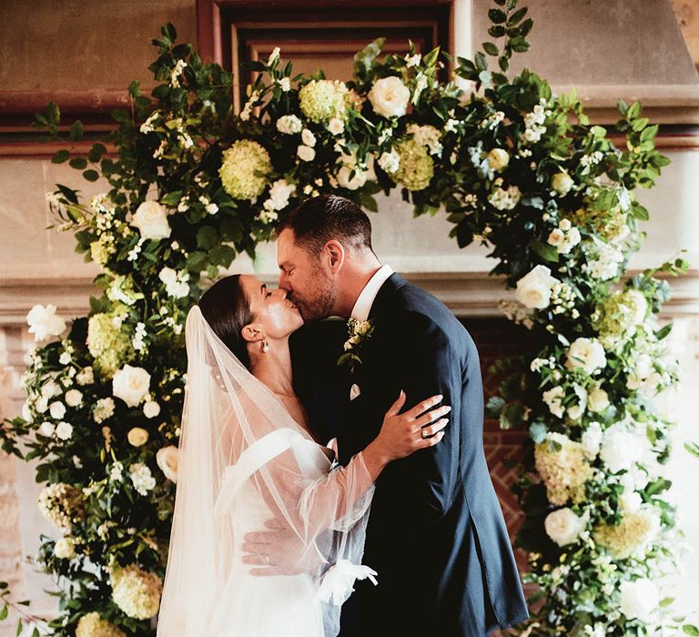 Bride & groom kiss during wedding ceremony