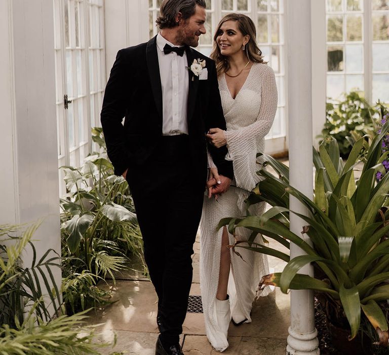 Black tie wedding at Tatton Park with groom in a tuxedo and bow tie and bride in a embellished wedding dress with front slit and white boots