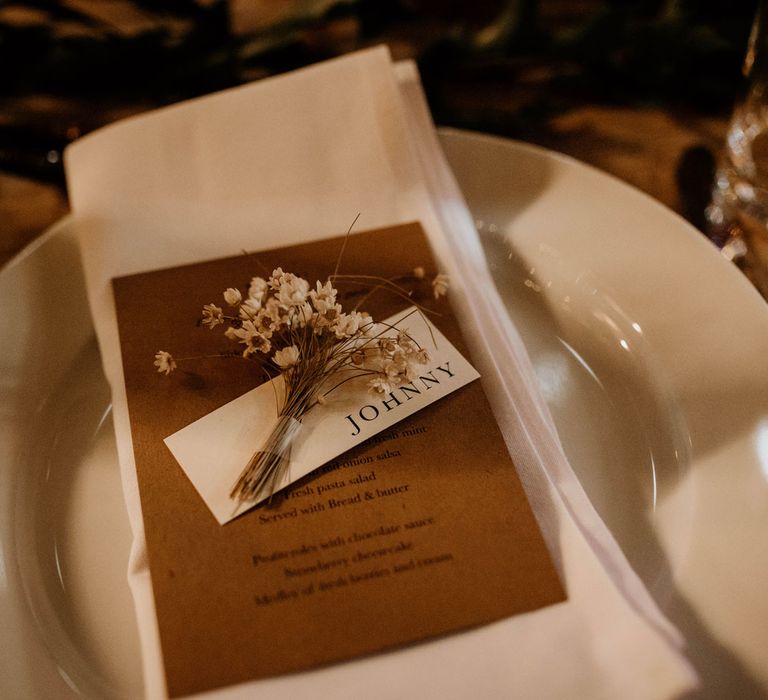 Rustic wedding table place with minimalistic table place names, dried florals and white napkin