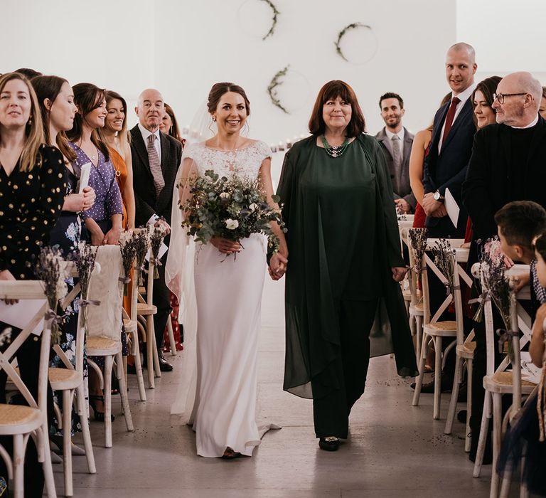 Bride walks down the aisle with her mother on her wedding day