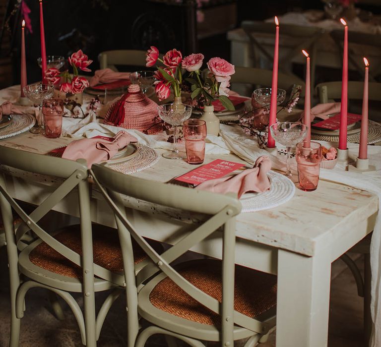 wedding reception table decor with coloured glass goblets, taper candles and wicker place mats 