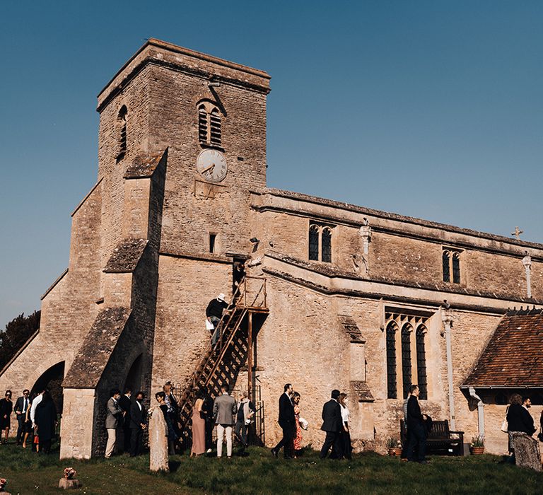 Wedding guests socialise outside of church where wedding ceremony was held