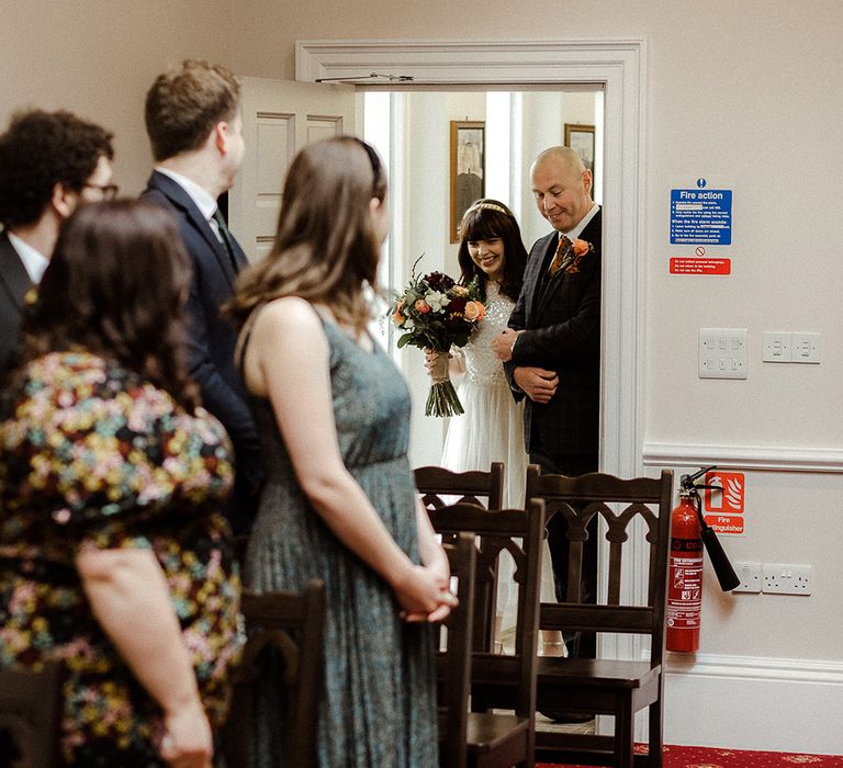 Father of the bride walks the bride down the aisle for registry office micro wedding