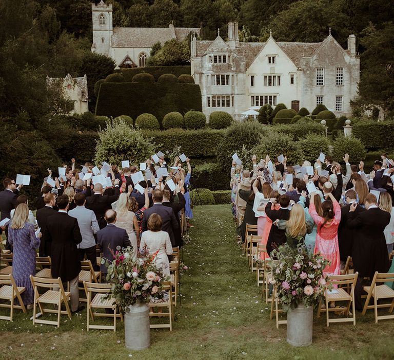 Wedding guests raise their hands for the handfasting ceremony 