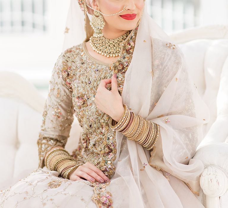 Bride wears traditional jewellery on her wedding day and red lipstick 