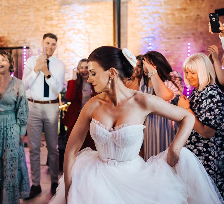 Bride dances with her wedding guests at her wedding 