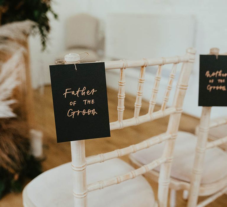 Black and gold tags with names and titles on to reserve the chairs 