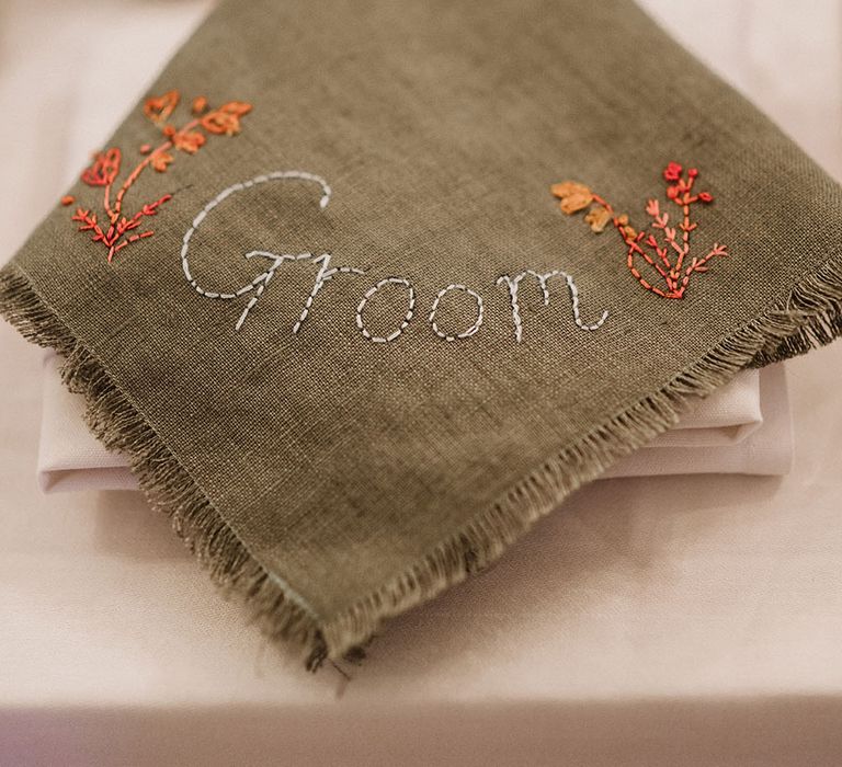 Green homemade napkin finished with name and orange embroidery 