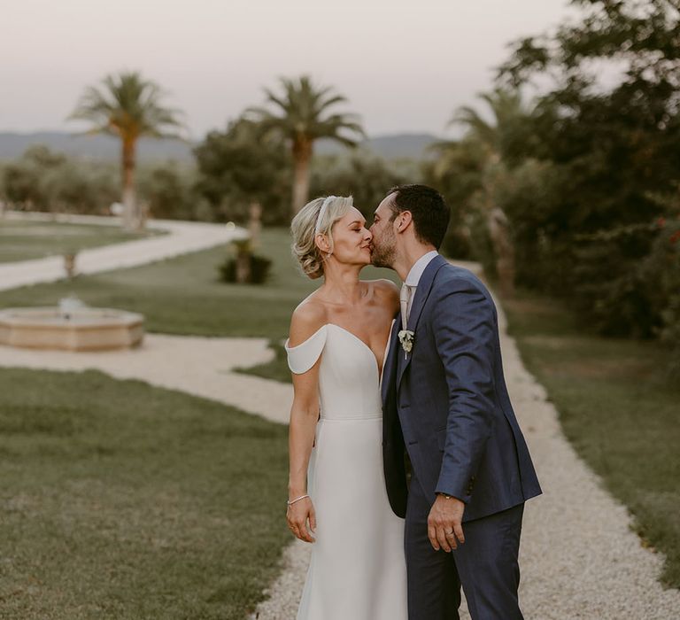 Groom kisses his bride outdoors after wedding ceremony in church 