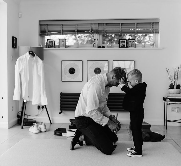 Grooms son helps him get ready during intimate moment before wedding ceremony in London