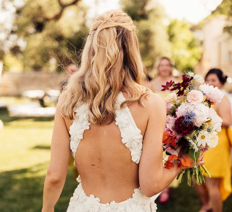 Bride in a flower Emma Beaumont wedding dress with a halter back style 