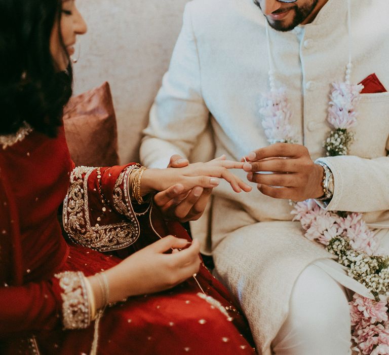 Groom places wedding ring on his bride during wedding ceremony 