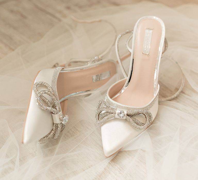 White pointed wedding shoes for the bride with sparkly bow detail and straps 