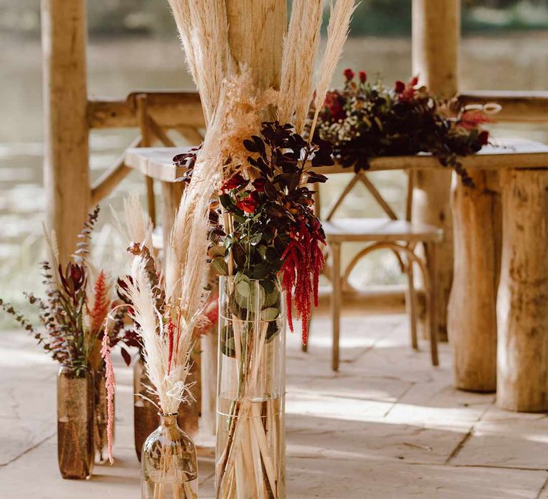 Pampas grass wedding flower decorations in large cylindrical glass vases with dried flowers and foliage at The Orangery Maidstone wedding venue 