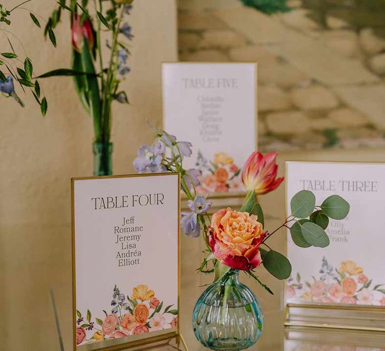 Botanical luxe floral wedding table numbers and bright blue glass bottles with dried flowers