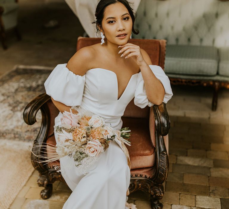 bride with pinned up hair in a strapless wedding dress with deep V front and puff sleeves