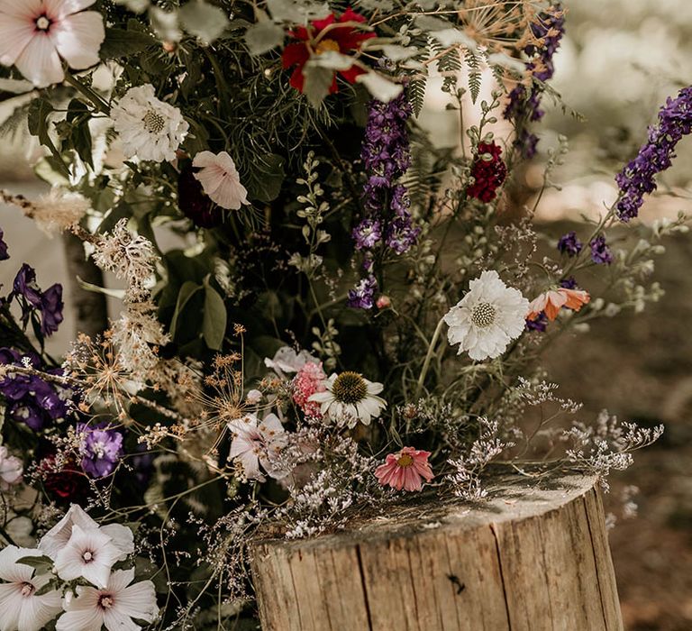 Purple and white wedding flowers decorating the woodland wedding venue 