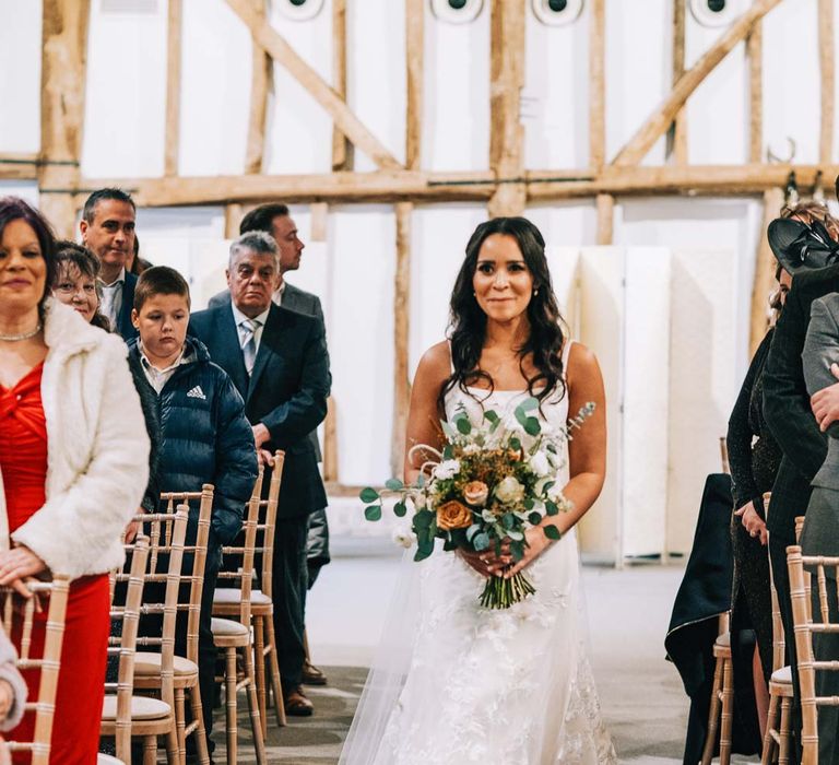 Bride holding pampas grass, eucalyptus, blush garden roses, dried flowers and foliage bridal bouquet walking down the aisle at South Farm wedding wearing a-line tulle wedding dress with beaded lace applique with petals and a square neckline with side tulle cutouts