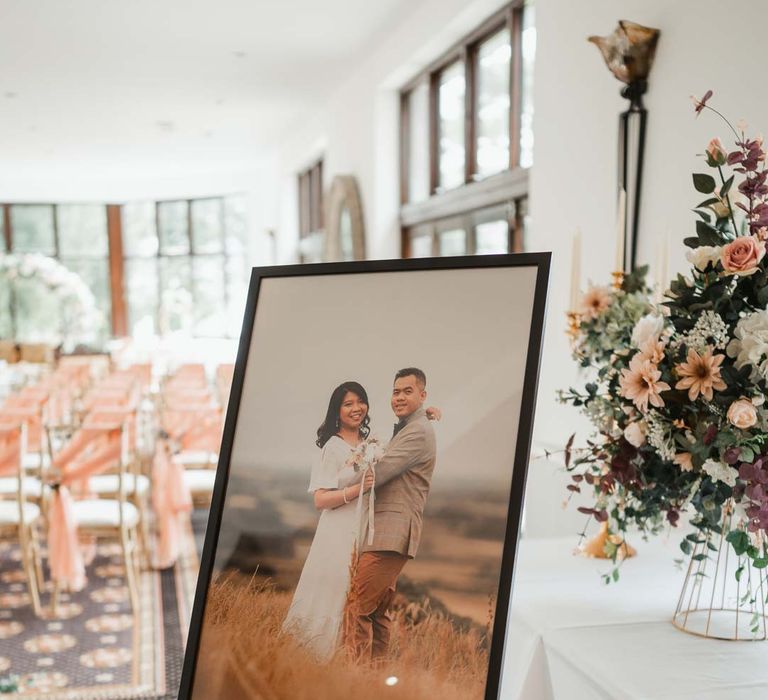 Portrait of the bride and groom in black rimmed photo frame on silver easel at Burmese wedding