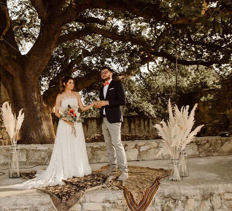 outdoor wedding ceremony for greece destination wedding with lilac bridesmaid dress pampas grass and wool rug decor