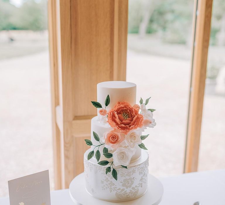 Classic white iced three tier wedding cake decorated with delicate flowers 