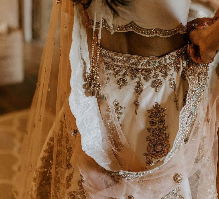 Bride wearing gold sparkly lehenga for the interfaith wedding blessing 