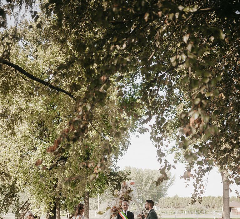 outdoor boho destination wedding with white wooden benches and pampas grass aisle wedding flowers 