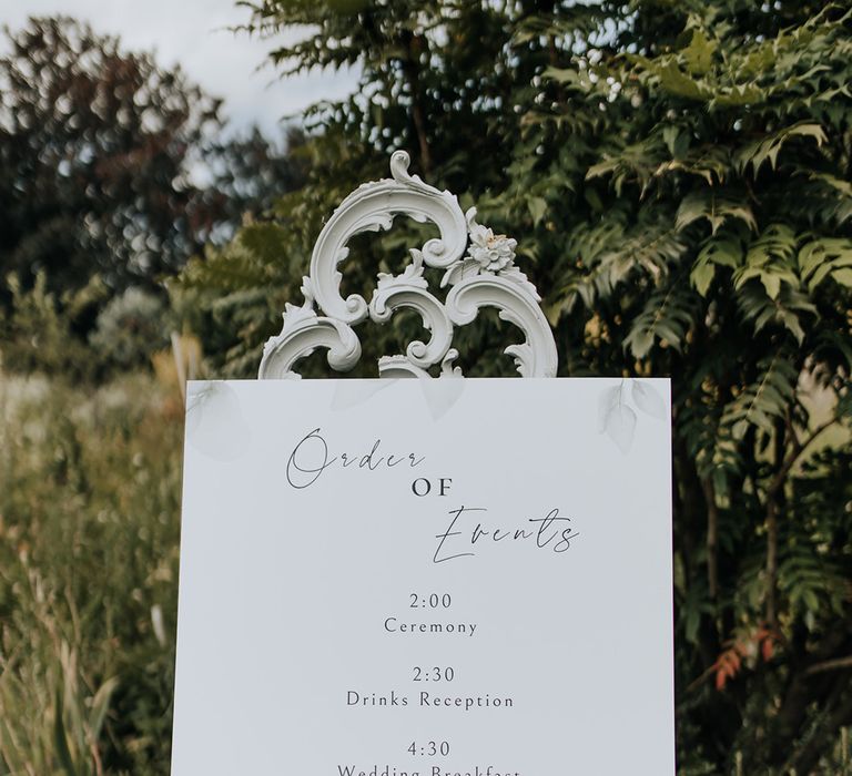 Whimsical minimalist wedding with white order of the day signage 