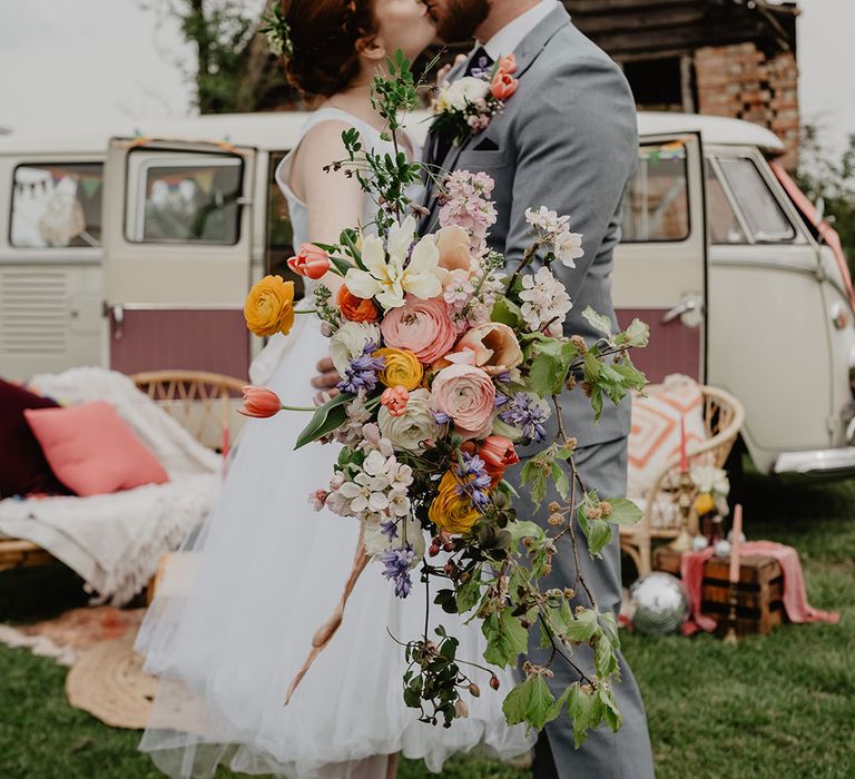 Bride holding oversized beautiful wedding bouquet with colourful flowers at festival wedding in the East Midlands 