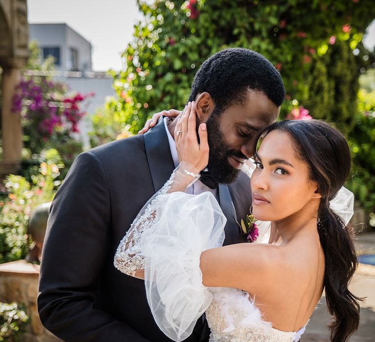 Bride wearing semi-sheer wedding dress with groom in black tuxedo at destination wedding in South Africa 