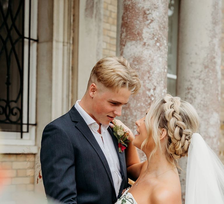 Groom in navy suit with bride in embroidered autumnal wedding dress 